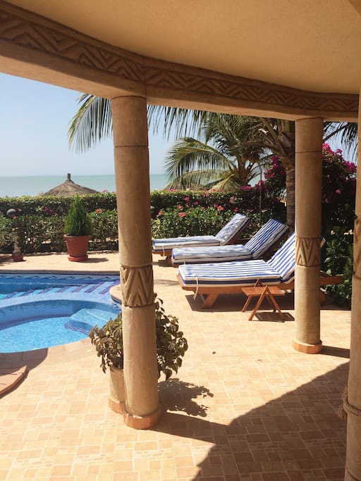 Blick von der überdachte Terrasse auf die pool Terrasse, Garten, Strand und Meer
