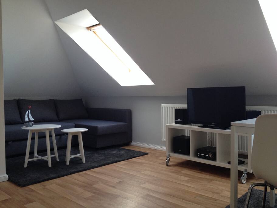 Wohnzimmer mit Schlafcouch und TV/Hifi