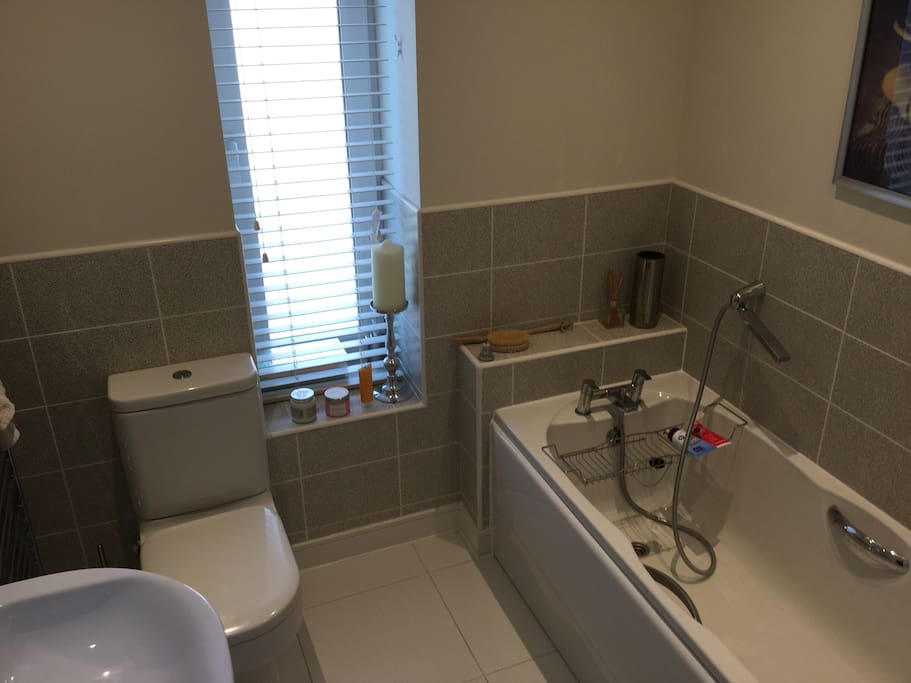 Private bathroom directly outside bedroom. Bath with shower head.