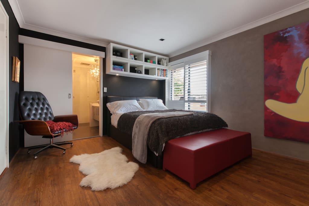 Bedroom 1, queen bed, ensuite bathroom (shower), opens to a deck and leafy private garden via glass sliding doors
