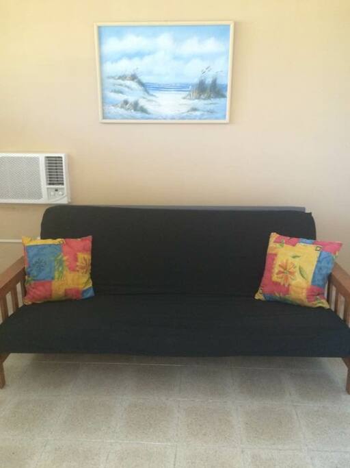 Living room: Futon for seating or sleeping. A/C. Also in room is an TV also included, small kitchen table and two chairs.