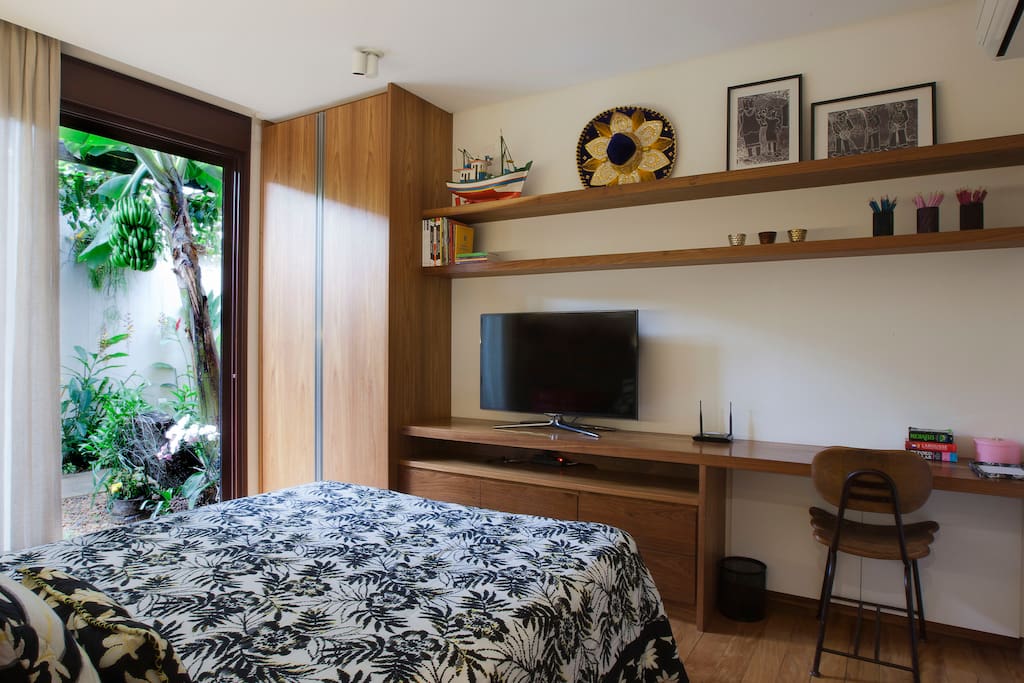 Suíte com cama queen size, Tv a cabo, frigobar, armário e bancada de trabalho.