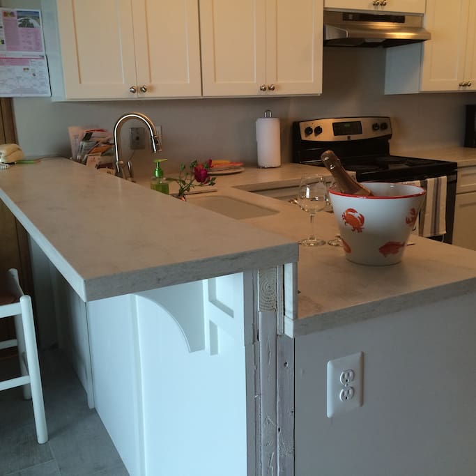Two tiered island hides messy kitchen from the living room area.