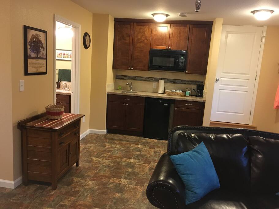 Kitchenette with fridge, sink, microwave, coffee pot, toaster, dishes and utensils