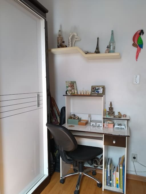 Mesa pequena com gaveta e cadeira.