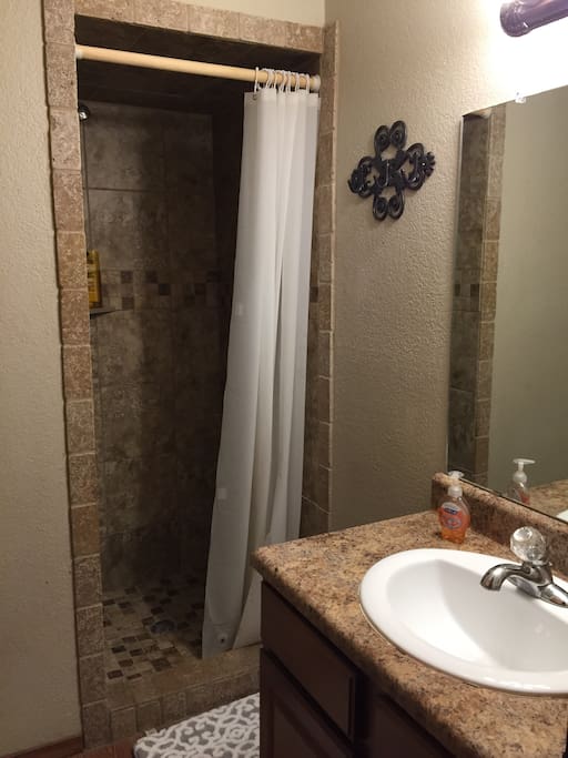 Bath two off bedroom with queen bed. Travertine tile shower.