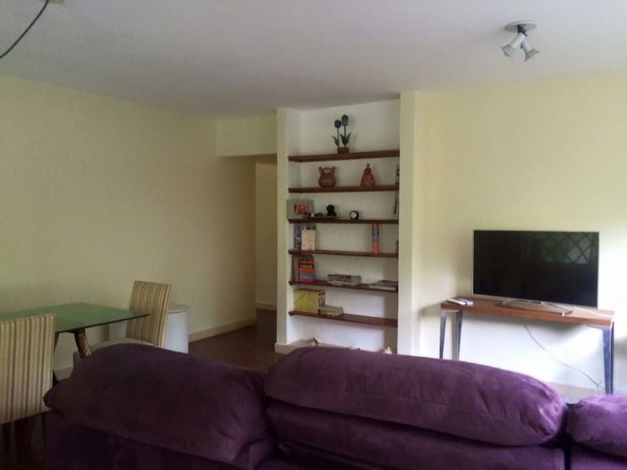 sala de tv com sofa grande, mesa de jantar e ar condicionado