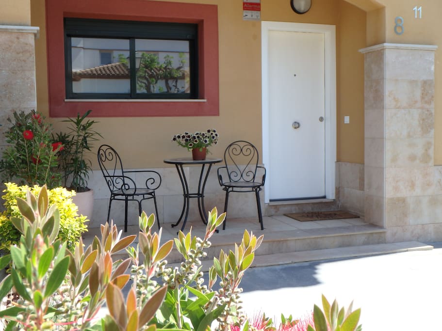 Entrance door and private garden with table plus 2 chairs.