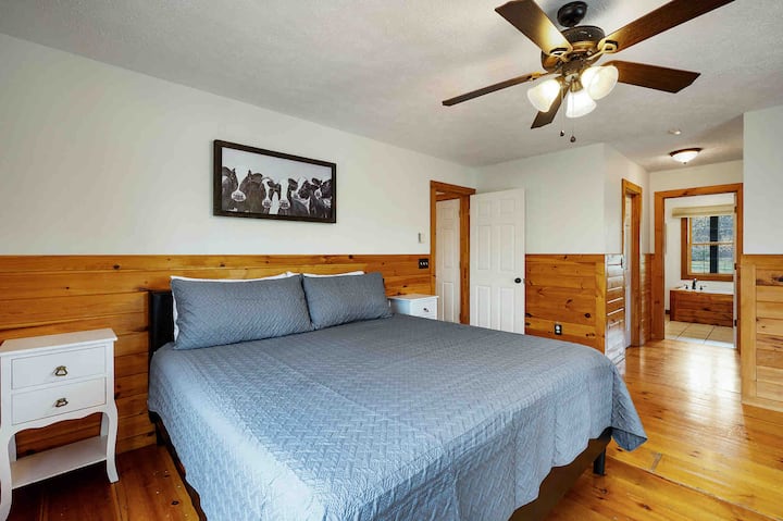 Master bedroom on main with king bed, tv, dresser, walk in closet, and french doors leading to the porch and outside seating area