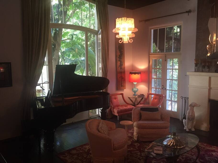 Welcome to Hollywood. Living room features a limited edition Steinway piano, a fireplace and a staircase right out of the movies.
