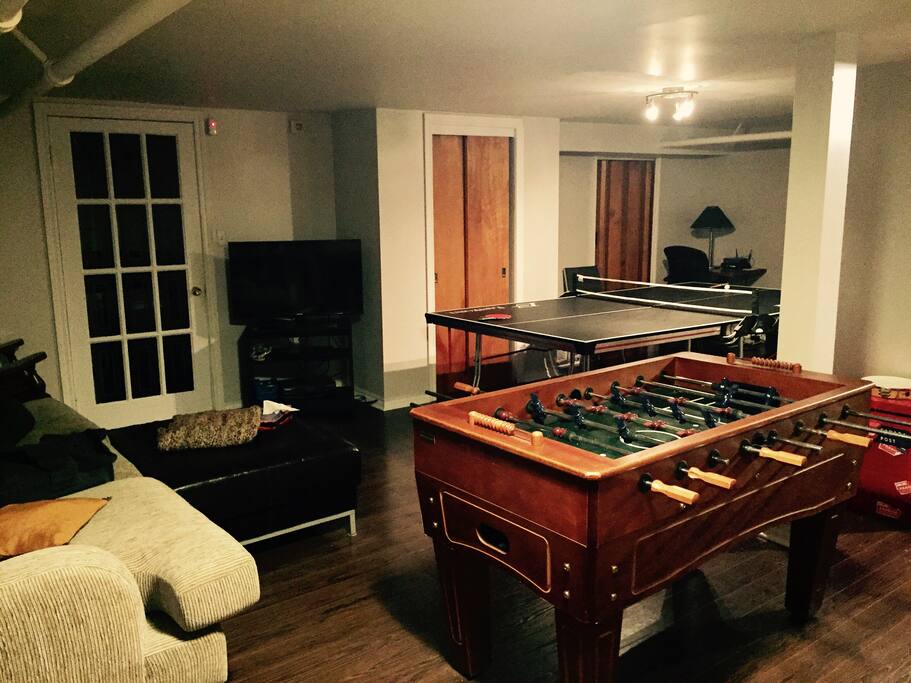 Sous-sol avec table de Ping-pong et table de babyfoot, télévision et sofa