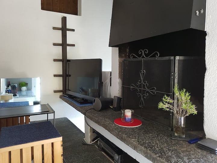 Rincón de la televisión y chimenea, y un paso a la cocina