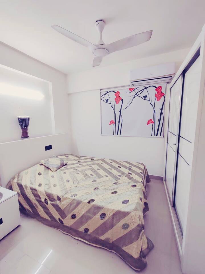 Bedroom with air conditioner, double bed and fully hydraulic storage, full height double door wardrobe, orthopaedic memory foam mattress with blanket and pillows.
