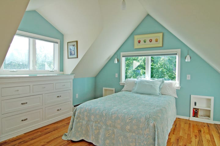 Dormitorio privado con cama de tamaño completo, armario, puerta y cortinas opacas. Televisión en esta habitación.