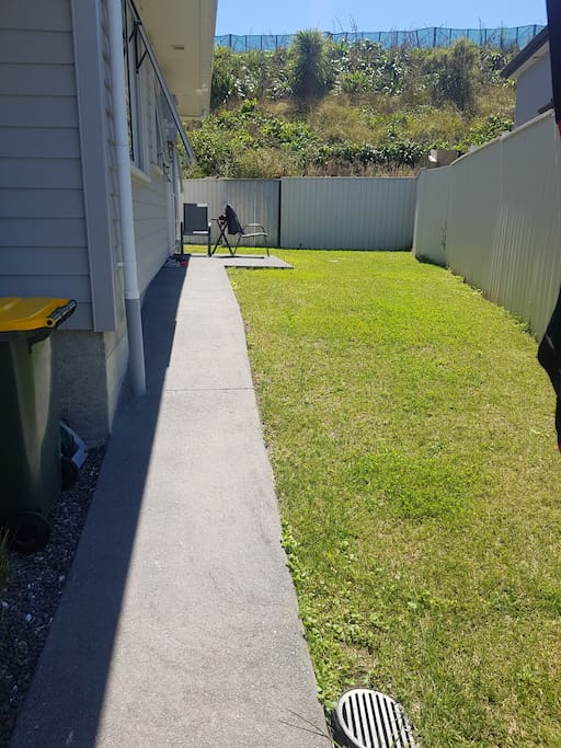 Private outdoor garden space which includes a patio area with seating and a small children's slide.