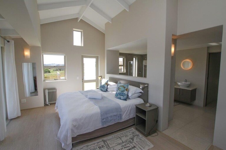 מיטה ראשית עם חדר אמבטיה צמוד ושירותים נפרדים.