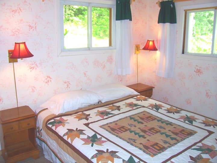 غرفة نوم كوين مع خزانة ملابس وخزانة ملابس.  توجد وحدة تكييف للكوخ بأكمله في غرفة النوم هذه