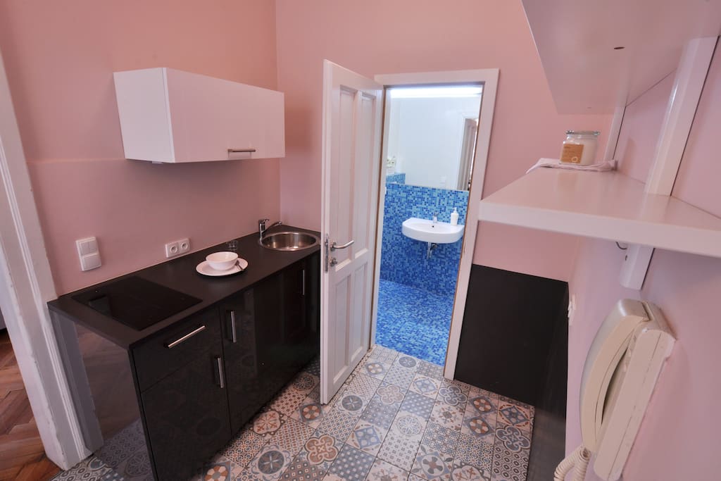 Practical and clean well equipted kitchen corner with the entrance to the bathroom