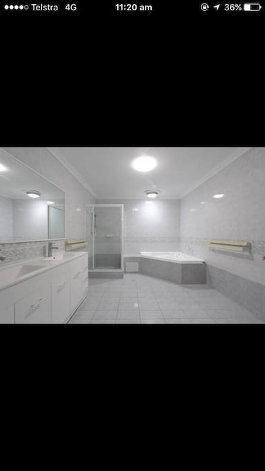 Your bathroom with double sink, toilet, shower and hot tub