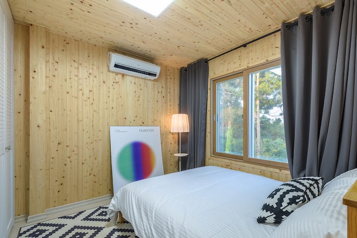 这是二楼的衣柜式卧室。照片左侧有3个大衣柜，房客可以使用其中一个衣物存放衣物。
衣柜中心提供额外的床上用品。