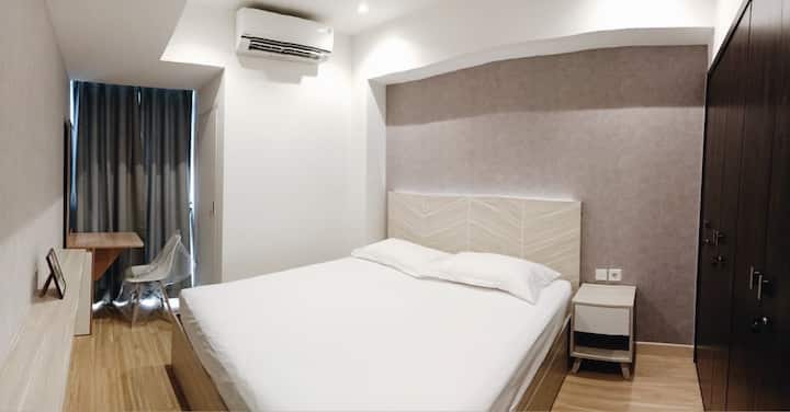 ห้องนอนพร้อมเตียงคิงไซส์โต๊ะข้างเตียงตู้เสื้อผ้าโต๊ะและเก้าอี้