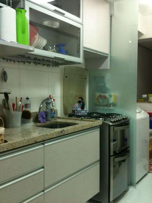 Cozinha equipada, com fogão a gás, forno de micro-ondas, geladeira e máquina de lavar roupas.