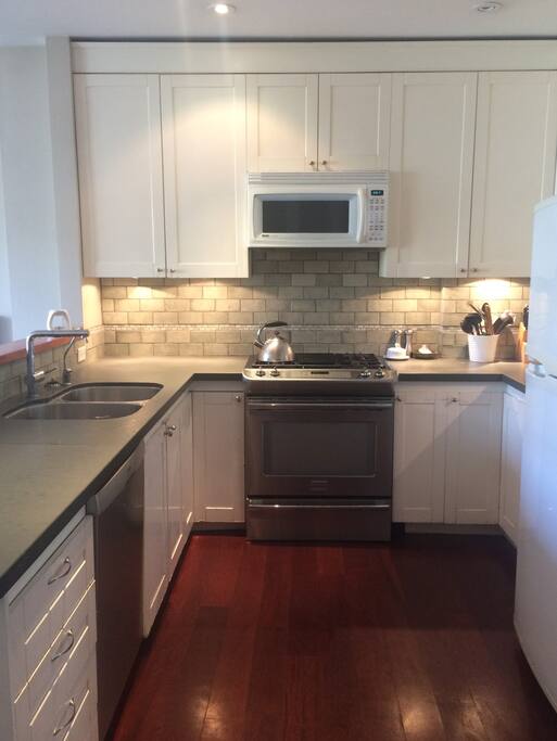 Kitchen - Slate counter, stainless steel appliances. Open concept to living room.