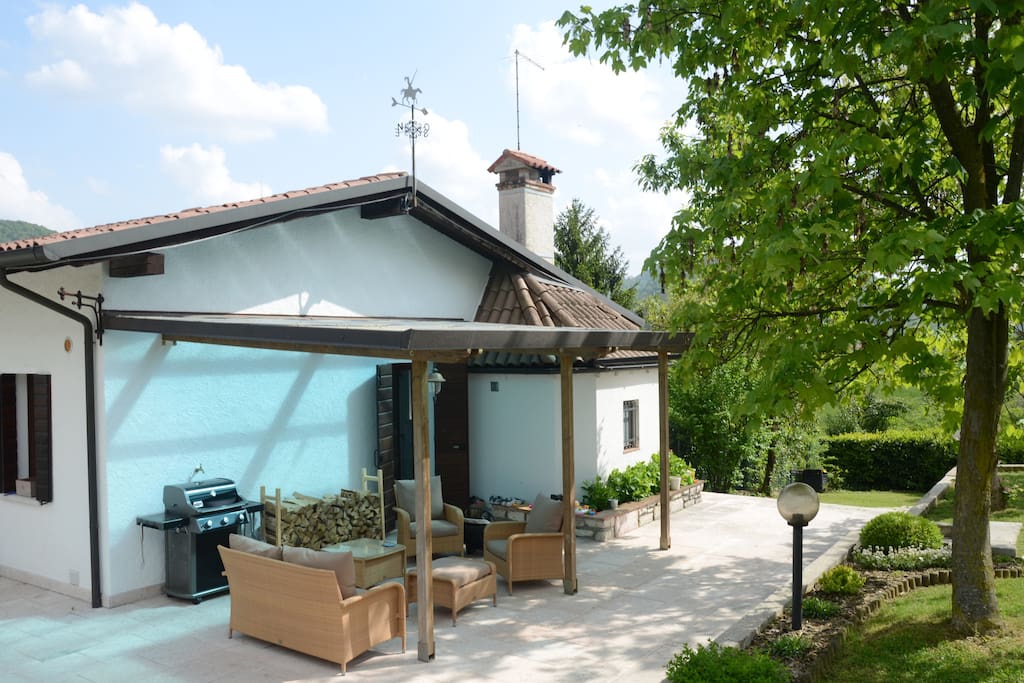 Covered porch area with comfy seating, equipped with an outdoor ceiling fan for warm summer nights.