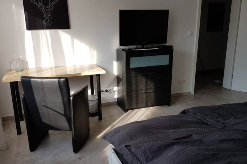 Kommode mit TV, Tisch und Sessel