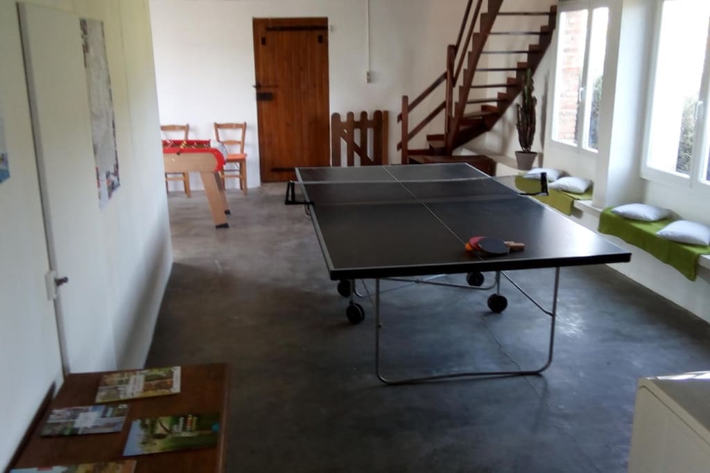 La salle de repos au rez-de- chausée, avec son babyfoot, sa table de ping pong, ses raquettes de badminton, sa plancha pour vos grillades...