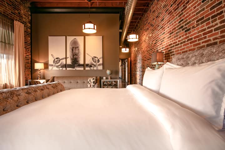 เตียงคิงไซส์ภายในห้องนอนใหญ่ผ้าปูที่นอนระดับพรีเมียมและผ้าม่านสีดำเต็มรูปแบบห้องนี้ยังมีสมาร์ททีวี 