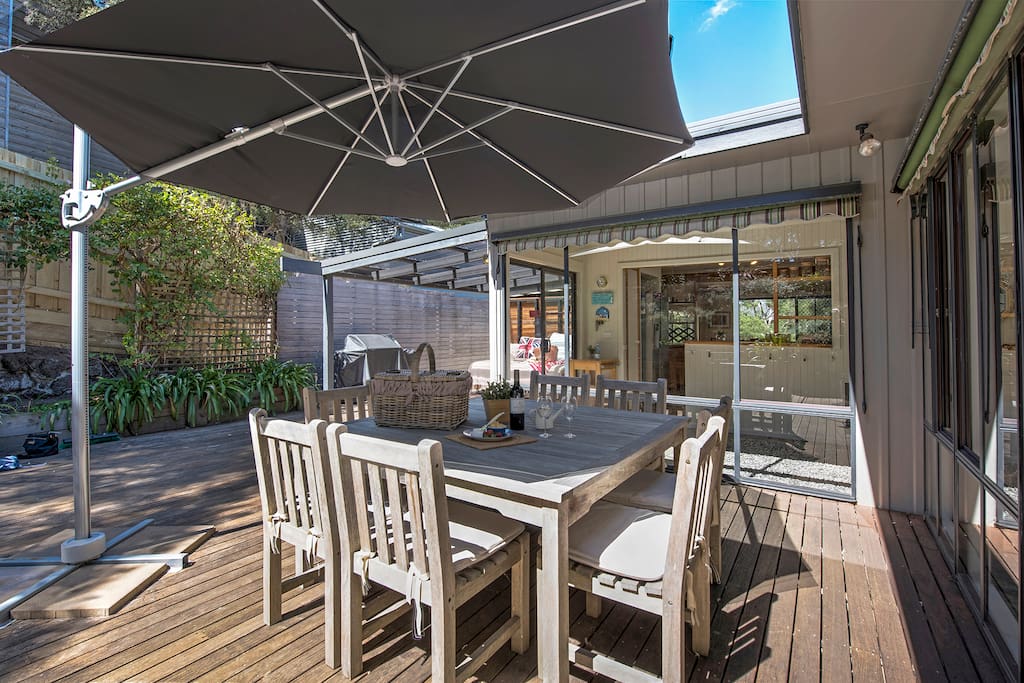 Under the large outdoor umbrella and window awnings - you can enjoy entertaining at the BBQ and dine outdoors