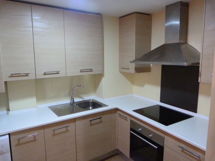 Cocina equipada con nevera-congelador combi alta gama, lavadora, microondas, horno, placa vitrocerámica, extractor de humos, tostador de pan, exprimidor de zumos, cafetera, batidora, menaje completo para cocinar, cubertería, y vajilla completa.