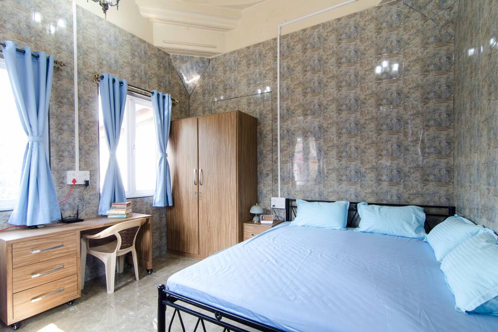 Interior of the tower room. Bed, desk, and wardrobe are visible. All of these were custom made. The windows on the left look out on over the building compound and onto the main road passing by. The room is well insulated from outside sound. The windows are Deceuninck UPC.