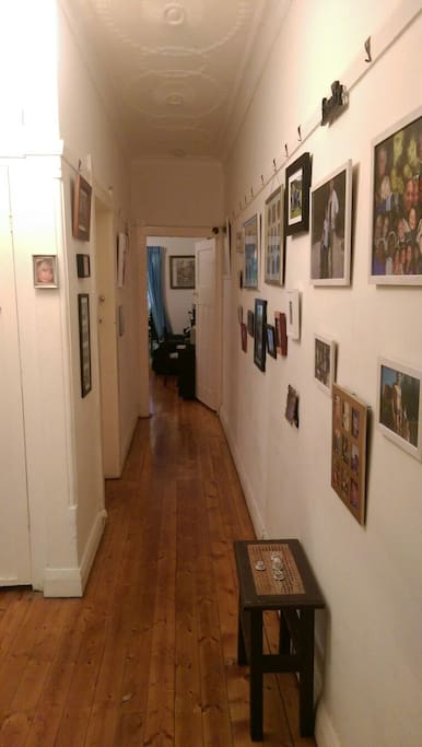 Entryway opens to the hallway which leads past the bedrooms and into the living space.