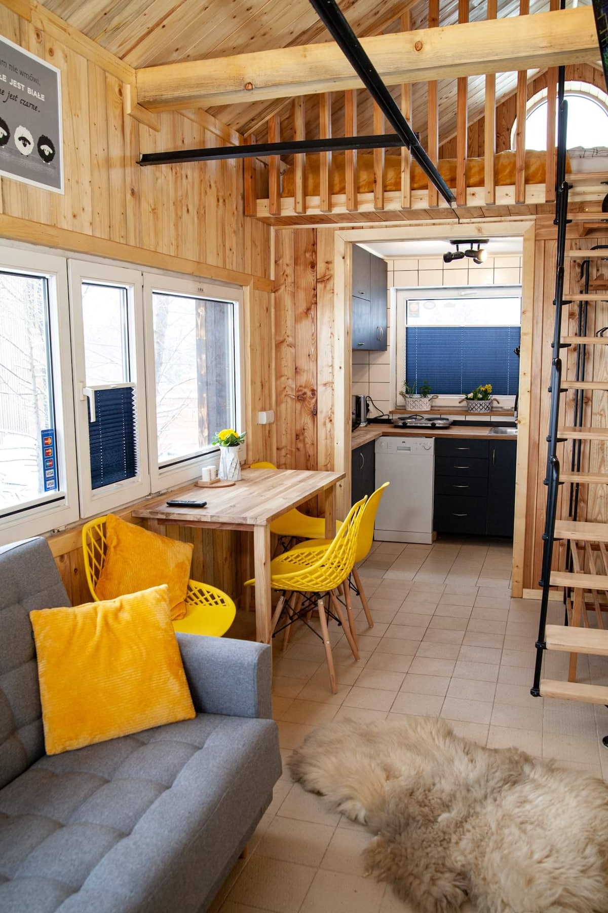 Een woonkamer/woonkamer met een uitschuifbare  bank en een tafel en stoelen. 