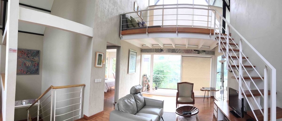 Tangga di ruang keluarga menuju attic tempat duduk santai dan tempat tidur double bed