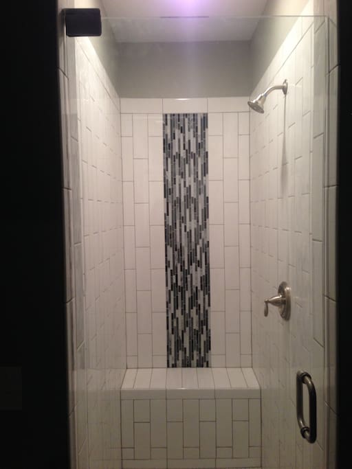 Walk in shower with sitting bench.