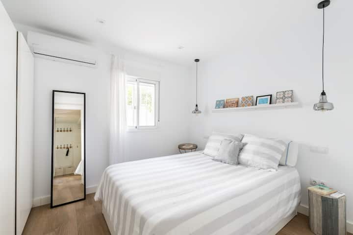 בחדר השינה יש מיטה נוחה ומראה אלגנטית, שיוצרת מרחב מרגיע ומואר היטב למנוחה אחרי יום של סיור בסביליה.