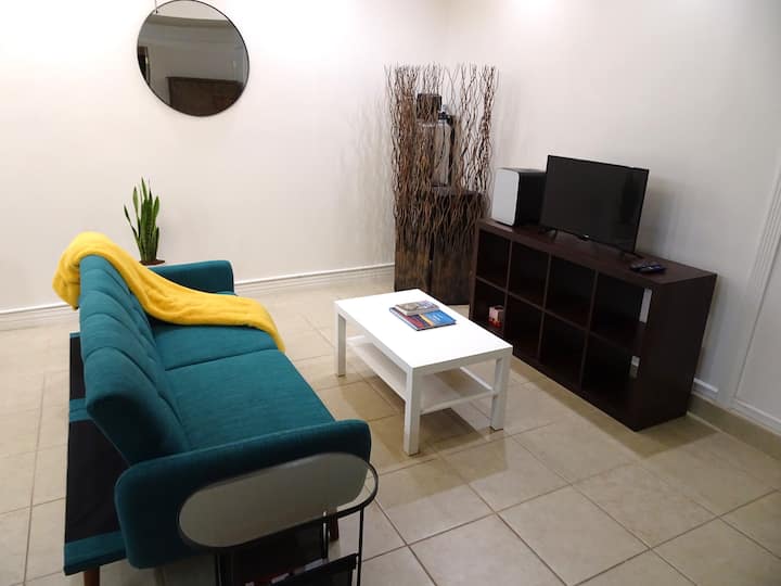 Sebule ndogo yenye televisheni janja na friji ndogo. 