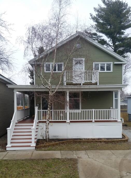 Stately historic home with a grand wrap-around front porch and an upper sundeck.
