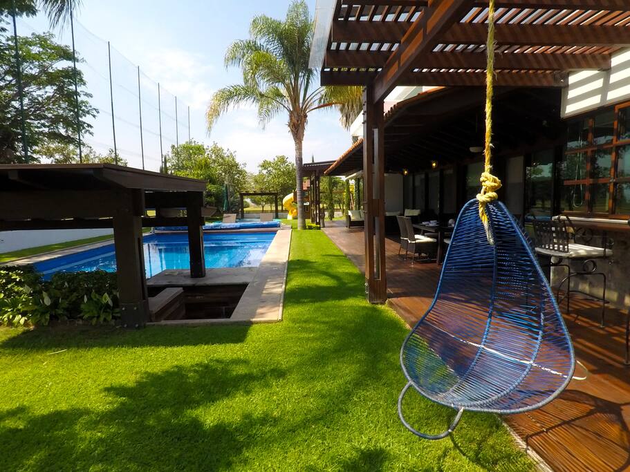Terraza con columpio, alberca y zona de juegos infantiles | Terrace with swing, swimming pool and playground area.