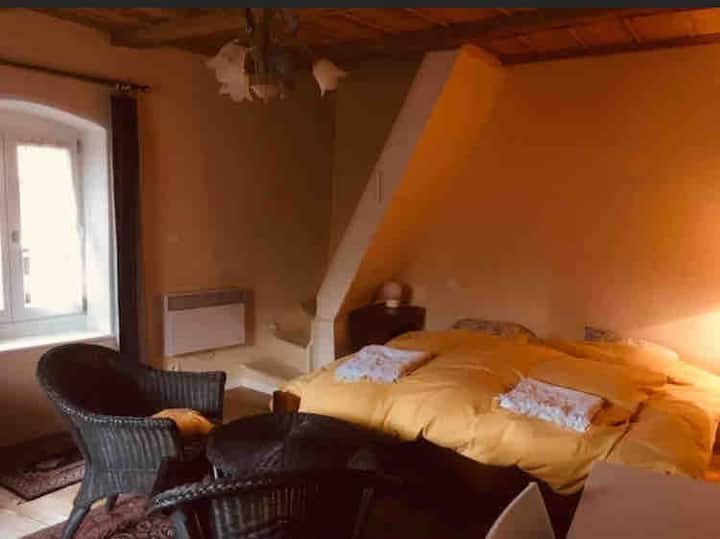 ダブルベッド1台、シングルベッド1台、折りたたみベビーベッド1台を備えた緑豊かな部屋。 