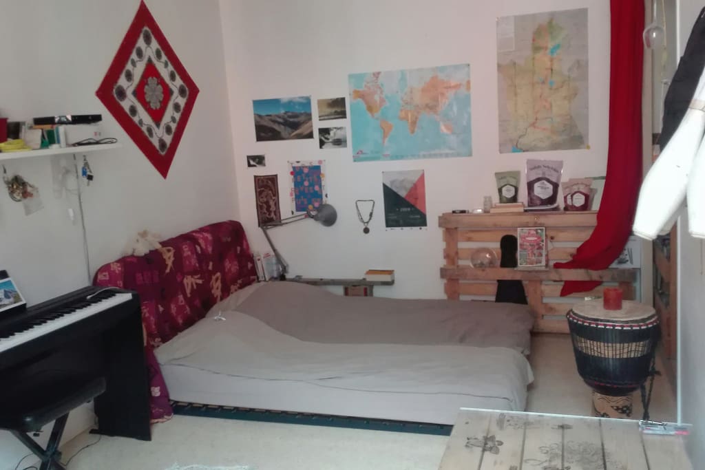 Lit double 140cm acheté neuf cette année (confortable) sur sommier. Attention au djembé aussi ! La cuisine est sur la droite, le rideau rouge sépare.