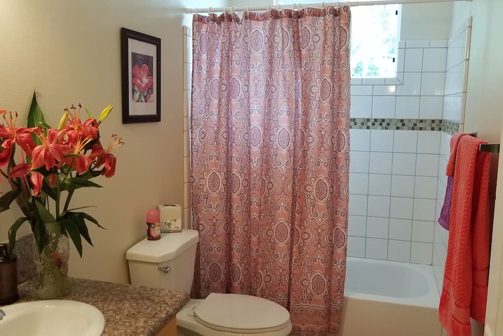 Full Bath with tiled tub and shower. Shampoo, conditioner, body wash,