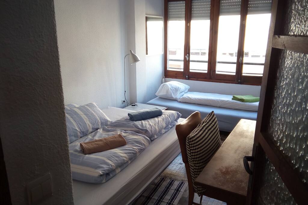 Helles Gästezimmer mit Doppelbett und Schlafsofa für 3 Personen und typisch spanischem Fliesenfußboden.