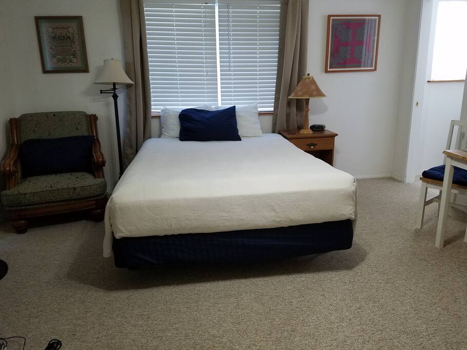View of queen size bed, sitting areas and entrance to bath