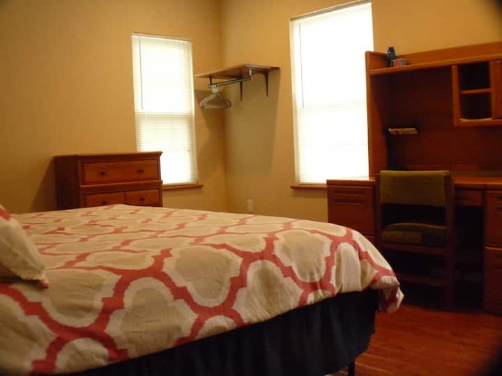 Dormitorio tamaño king con oficina/área de trabajo en el primer piso.  