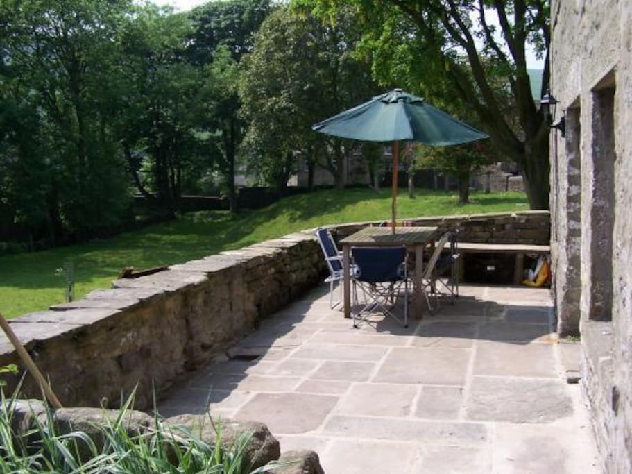 The front door leads onto a large south facing patio terrace, overlooking the beck and village green. Equipped with garden furniture and a BBQ/Brazier.
NB Care must be taken with small children as there is a drop into the field from the terrace wall.