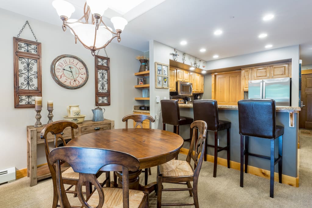 Seating for 4 in the dining area with circular wood table.